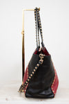 Black and red handbag with gold studs on a white background