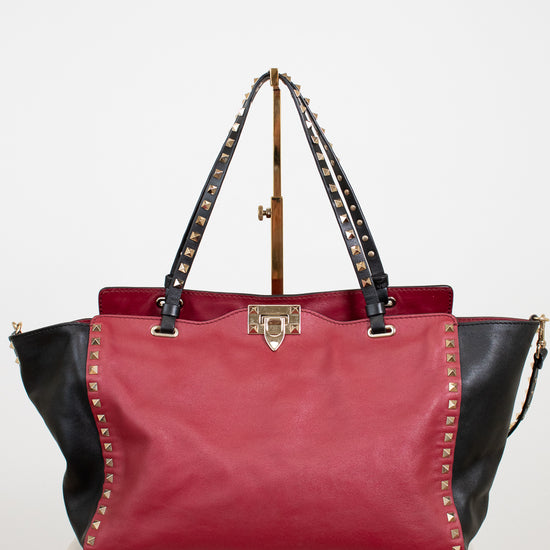 Red and black handbag with studded details on a white background