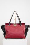 Red and black handbag with studded details on a white background