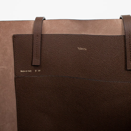 Brown leather bag with visible brand name on a white background
