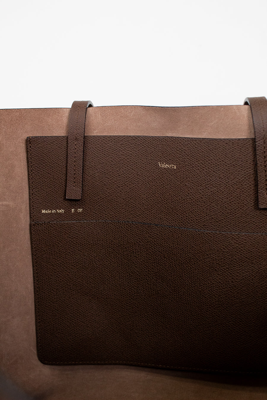 Brown leather bag with visible brand name on a white background