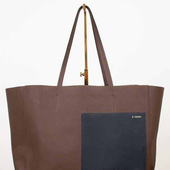 Brown tote bag with a black pocket on a white background