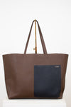 Brown tote bag with a black pocket on a white background