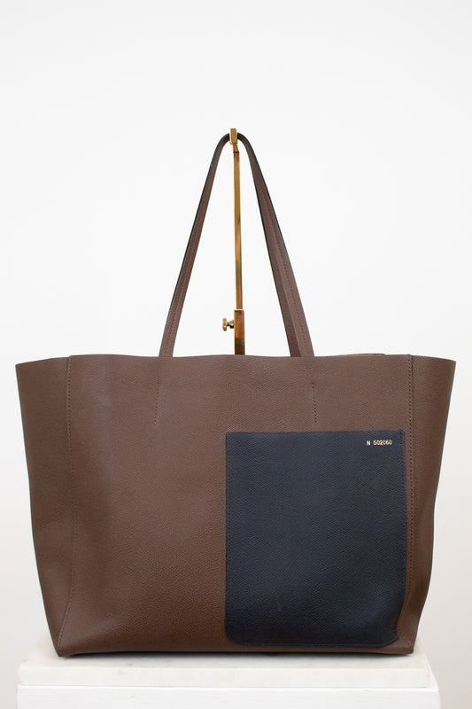 Brown tote bag with a black pocket on a white background