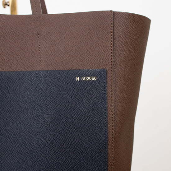 Brown tote bag with a visible brand logo on a white background
