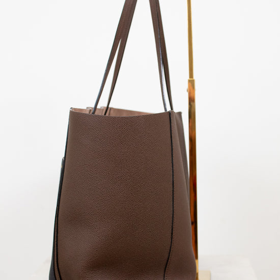 Brown tote bag with black accents on a white background