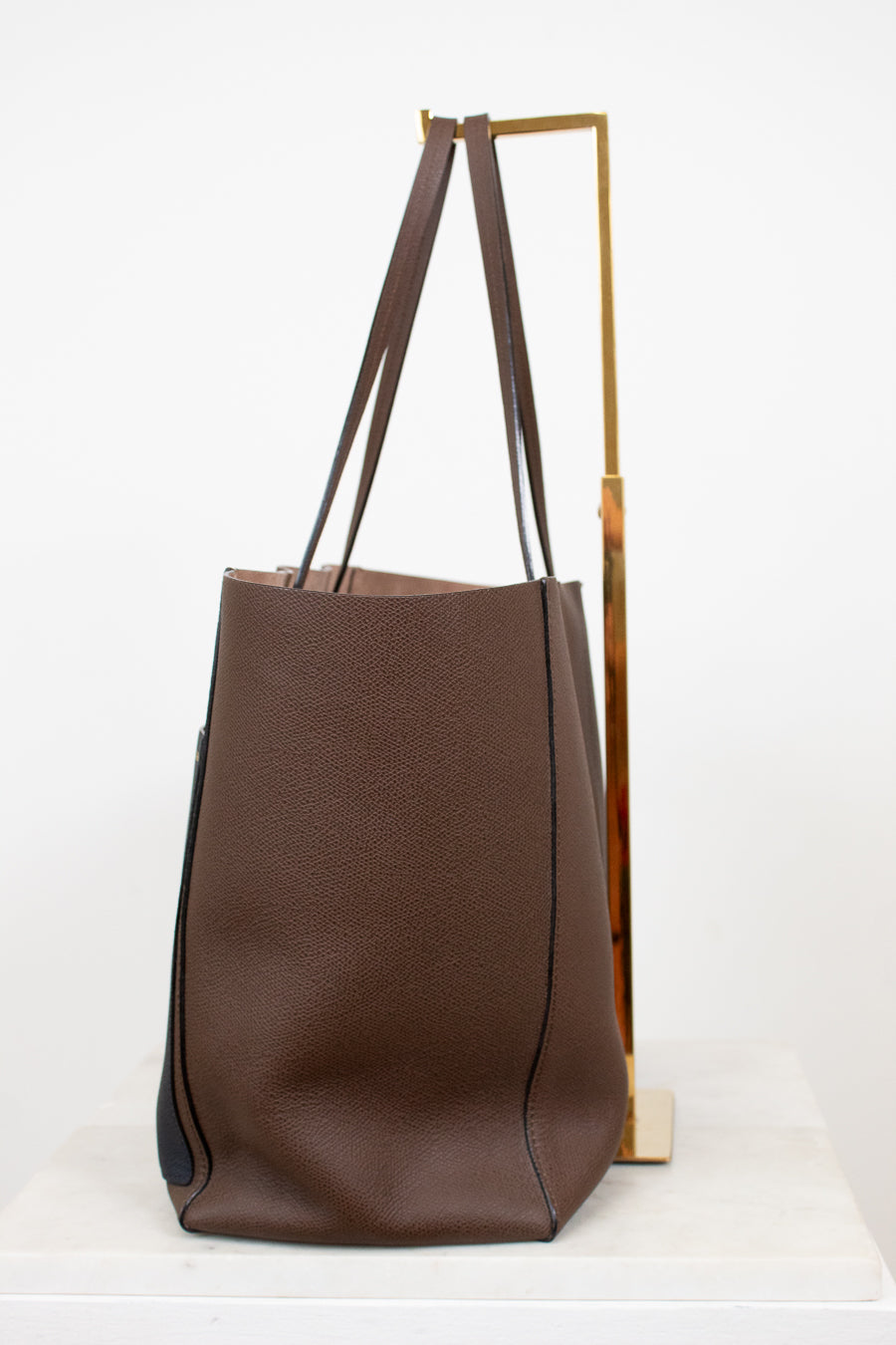 Brown tote bag with black accents on a white background