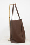 Brown leather tote bag with wooden handle on a white background