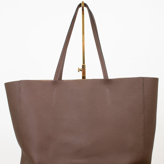 Brown tote bag with a gold clasp on a white background