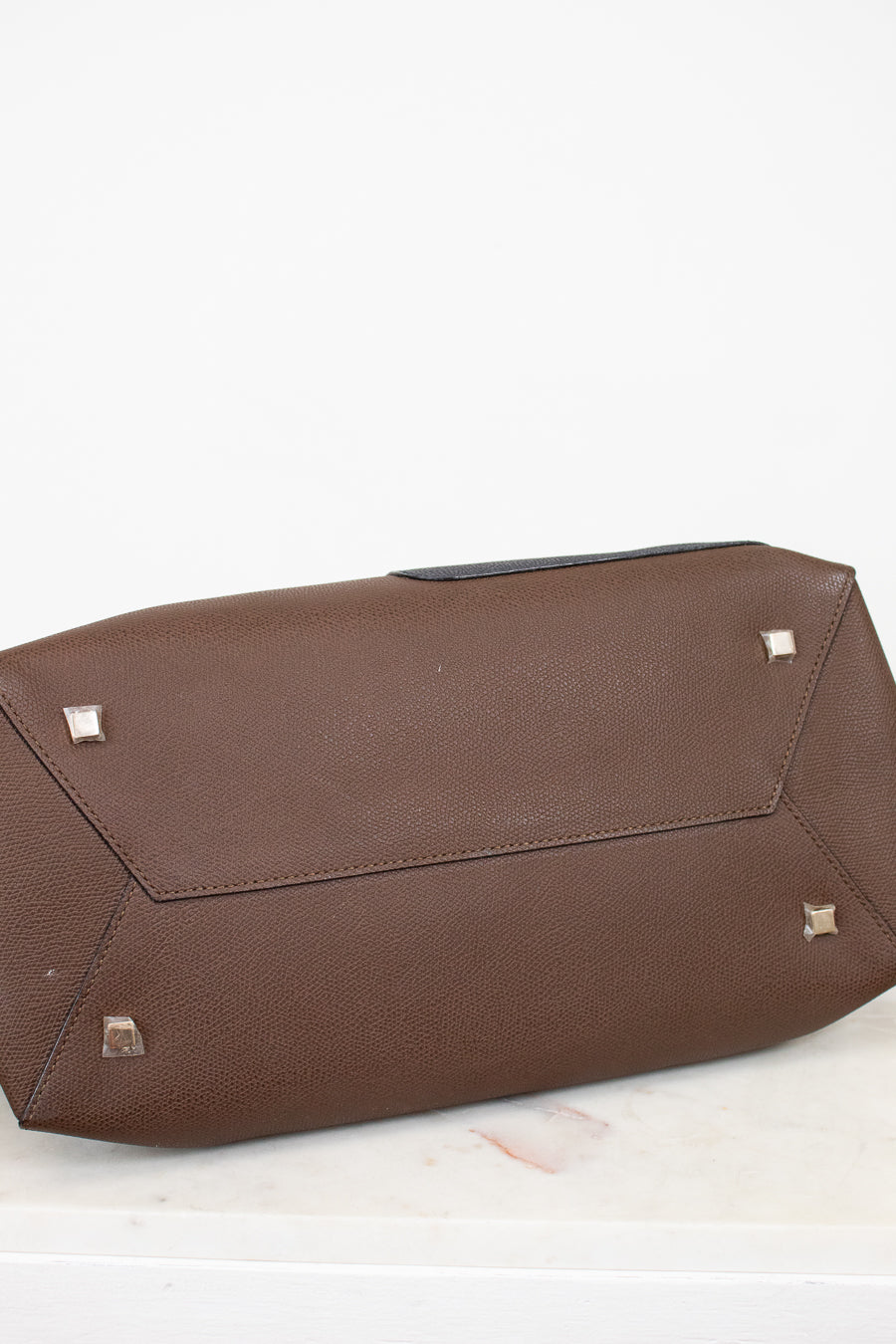 Brown base of bag with silver studs on a white background