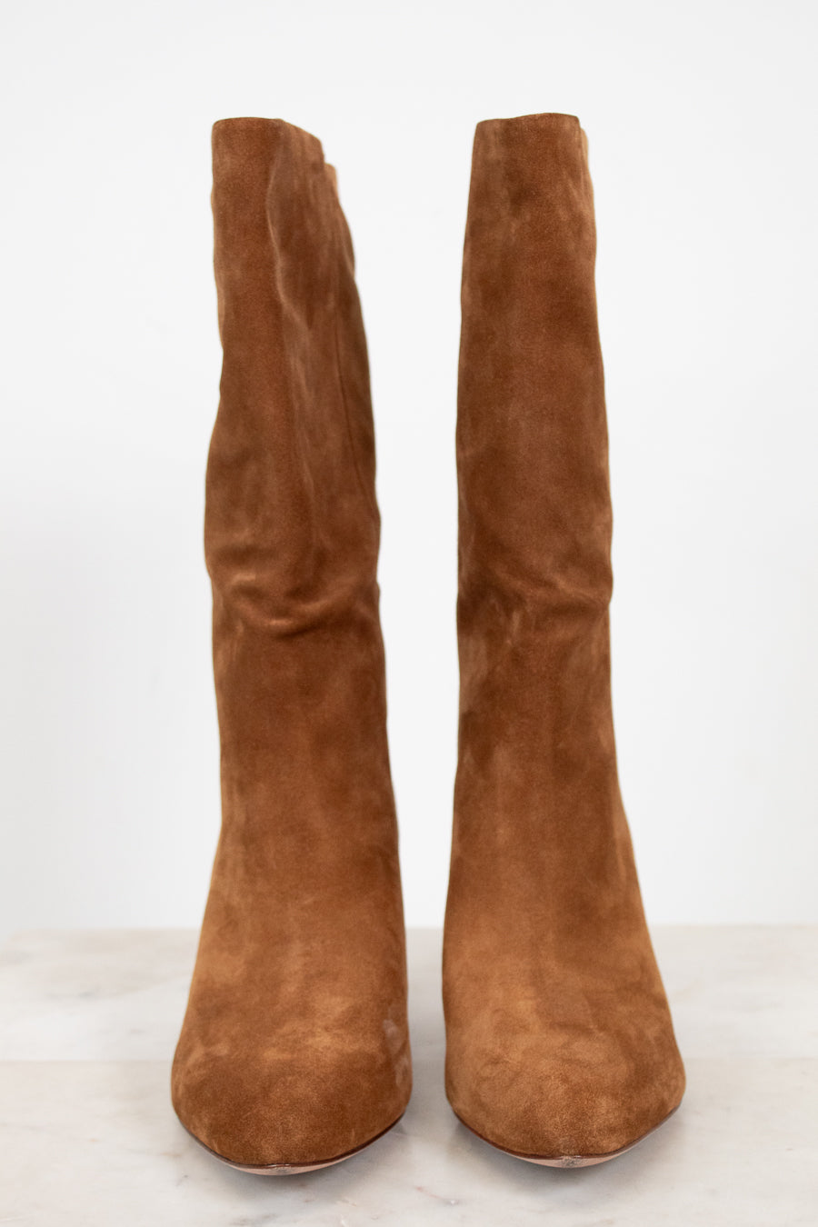 Pair of brown suede knee-high boots on a white background