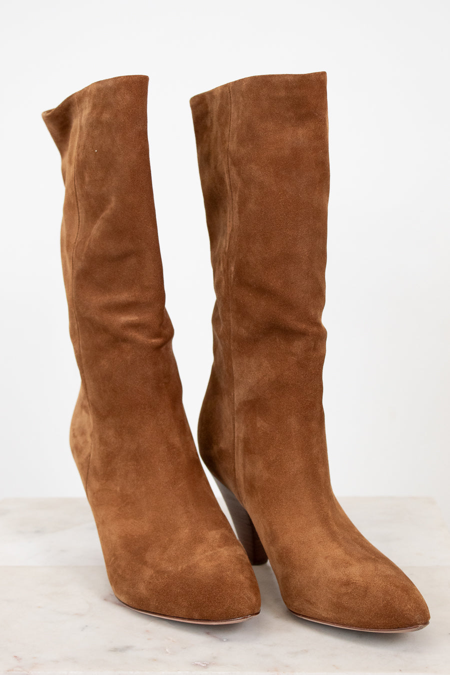Pair of brown suede knee-high boots on a white background