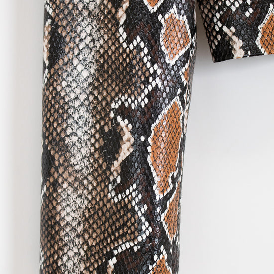 Close-up of snake skin patterned fabric on a white background