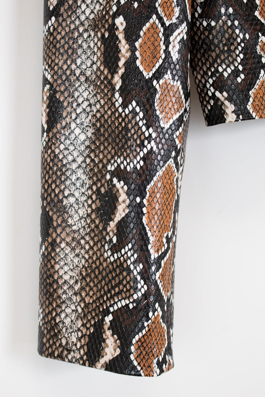 Close-up of snake skin patterned fabric on a white background