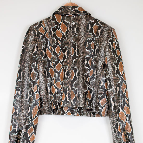 Snakeskin patterned jacket on a hanger against a white background
