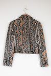 Snakeskin patterned jacket on a hanger against a white background