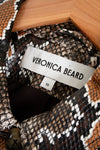 Close-up of a patterned garment with a Veronica Beard label inside a wooden box.