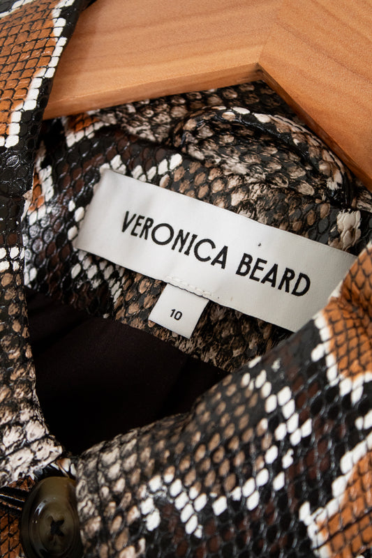 Close-up of a patterned garment with a Veronica Beard label inside a wooden box.