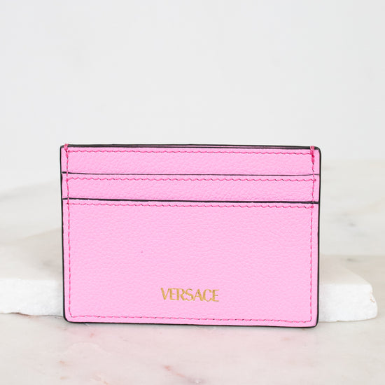 Pink Versace cardholder on a light marble background