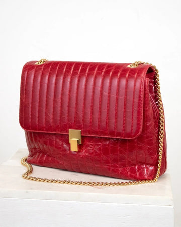 Red handbag with gold chain and clasp on a white background