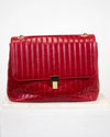 Red textured handbag with gold accents on a white background