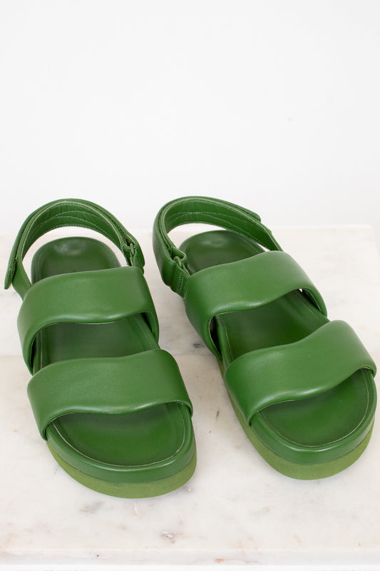 Green sandals on a white marble surface