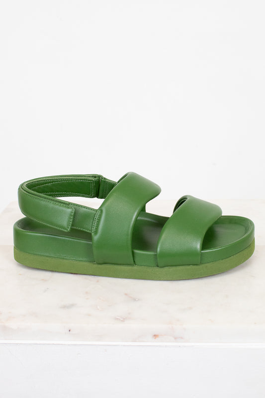 Green sandal on a light beige background