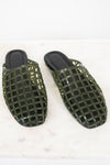 A pair of olive green open-toe mule sandals with a glossy grid pattern, displayed on a white marble surface against a white background.