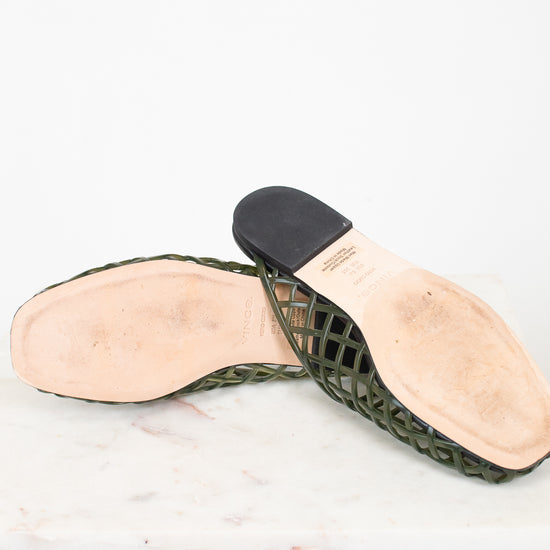 A pair of women's green woven mesh slingback sandals with black heel caps and light beige insoles, displayed on a white marble surface against a white background.