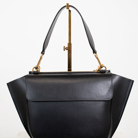 Black handbag with gold accents on a white background