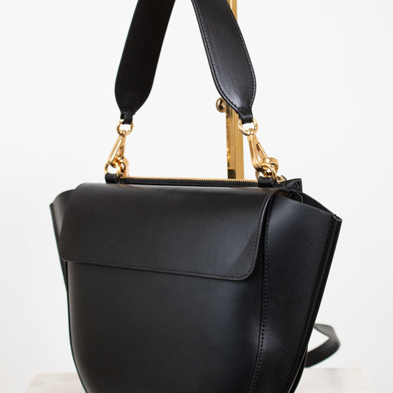 Black handbag with gold accents on a white background