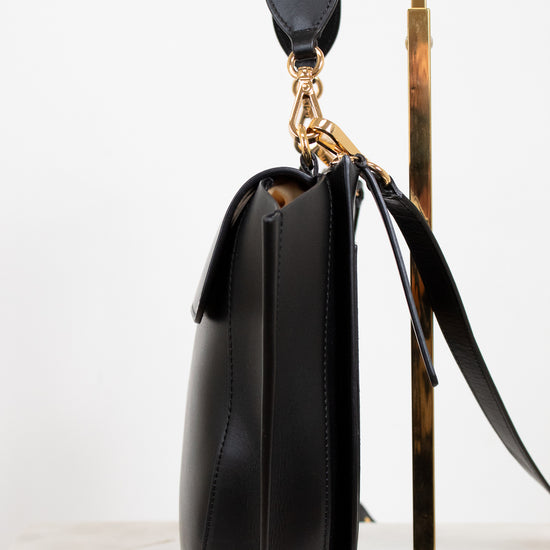 Black handbag with gold accents on a white background