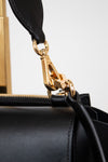 Black handbag with a gold clasp on a white background