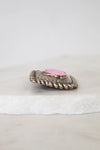 Decorative object with pink center and textured surface on a white background