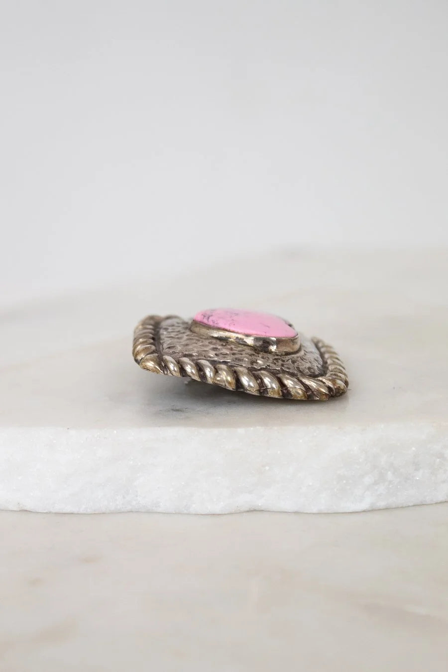 Decorative object with pink center and textured surface on a white background