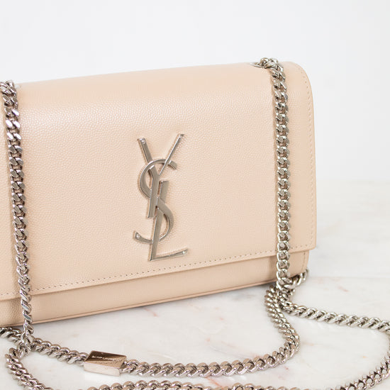 Beige handbag with chain strap on a light background