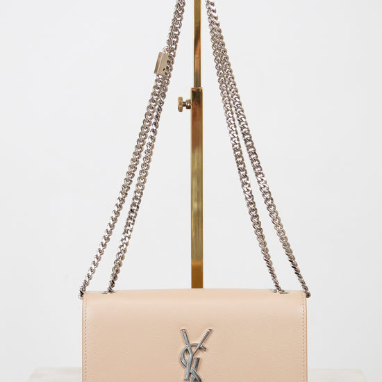 Beige handbag with chain strap on a white background