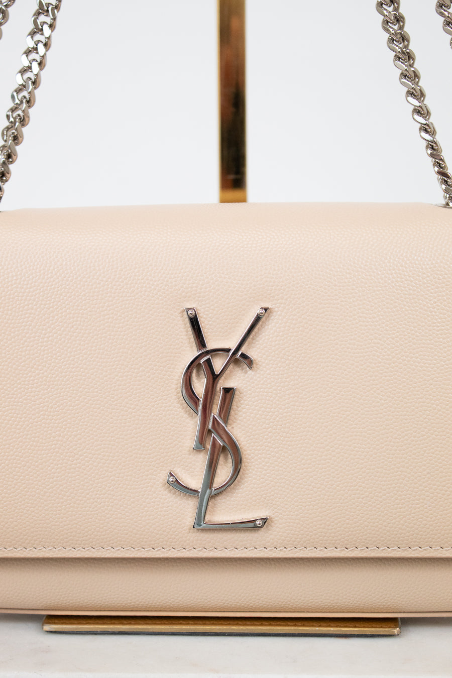 Beige handbag with a prominent logo on a white background