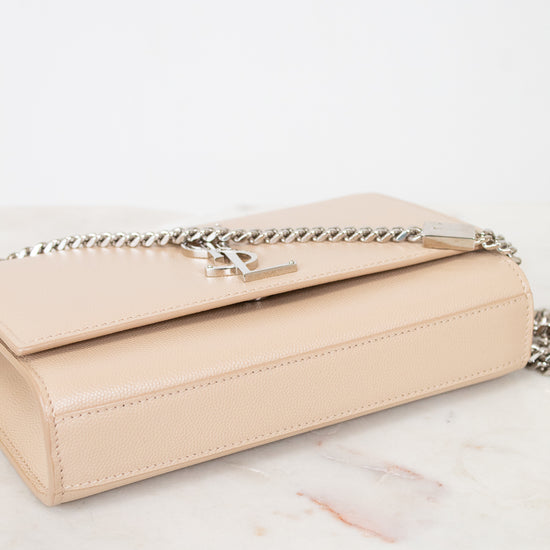 Beige handbag with a chain detail on a marble surface