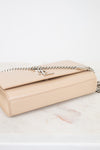 Beige handbag with a chain detail on a marble surface