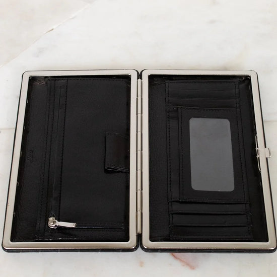 Black wallet with silver trim on a white marble surface