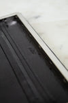 Black leather wallet with a brand logo on a marble surface