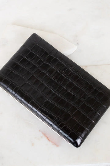 Black crocodile-patterned clutch bag on a light background