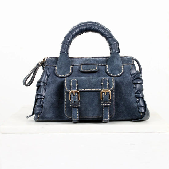 Blue handbag with a buckle detail on a white background