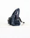 Blue leather handbag with ruched details on a white background