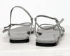 Pair of gray sandals with thin straps on a white background