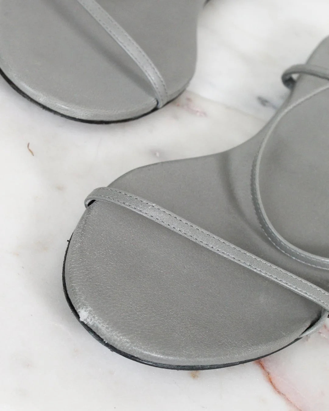 Gray sandal on a white surface