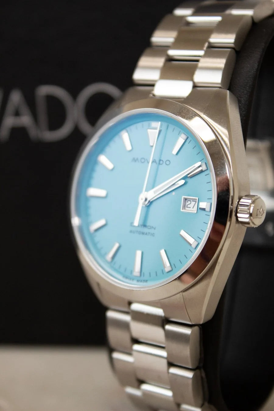 Silver watch with a blue face on a black background