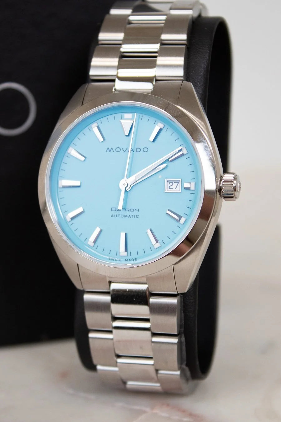 Silver watch with a blue face on a marble surface