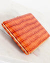Orange crocodile-patterned wallet on a light background